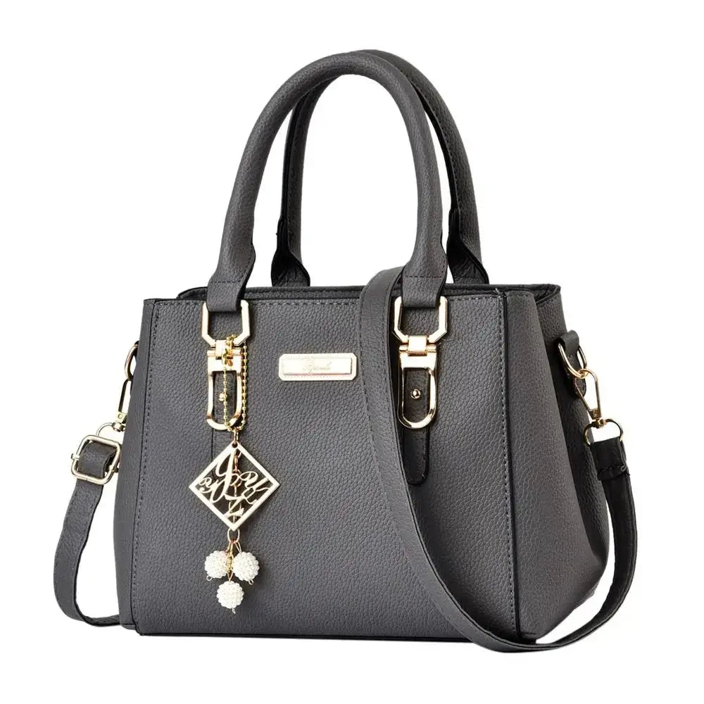 Gray structured handbag shown from an angled side view with gold-tone details.