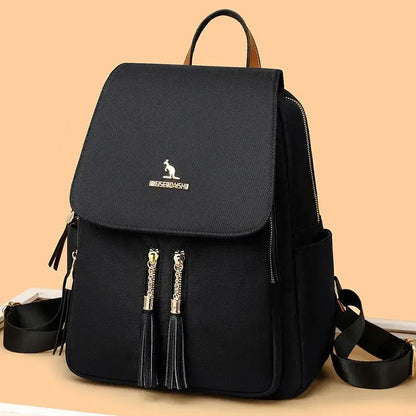 Black Oxford backpack displayed against a beige background with gold-tone zipper details.