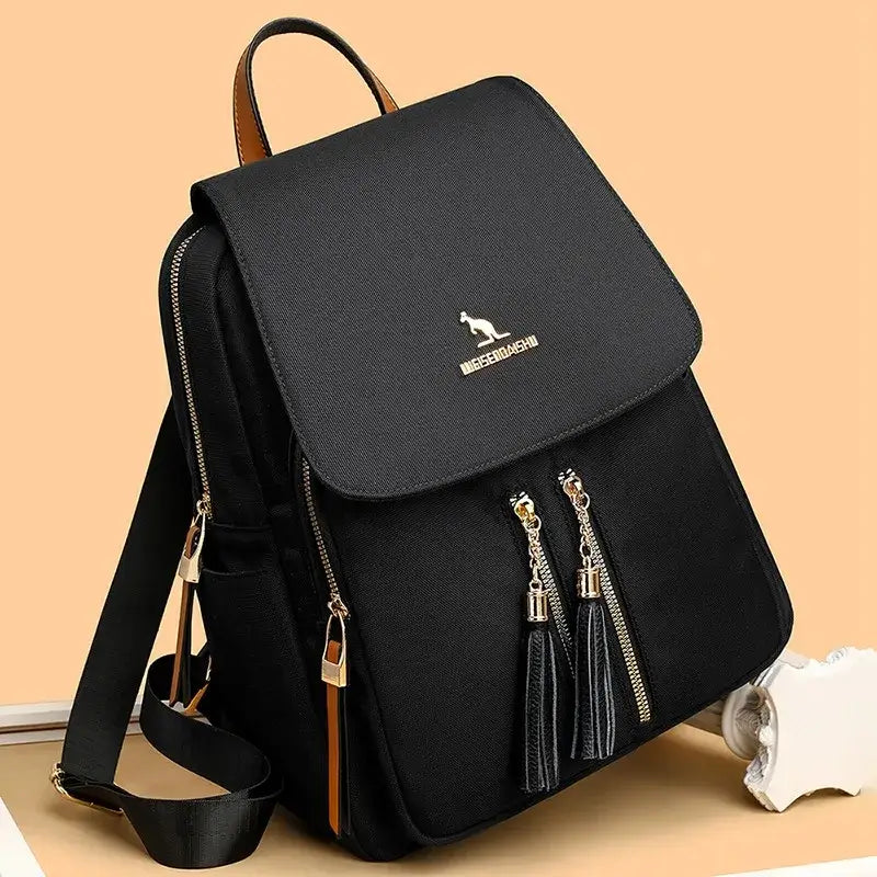 Black Oxford backpack with front flap, gold-tone zippers, and adjustable shoulder straps.