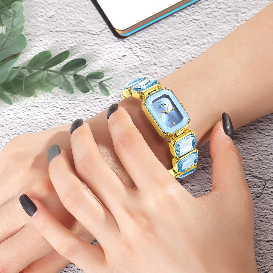 Gold Bracelet Watch for Women Rectangular Dial with blue decorative stones, shown worn on a wrist
