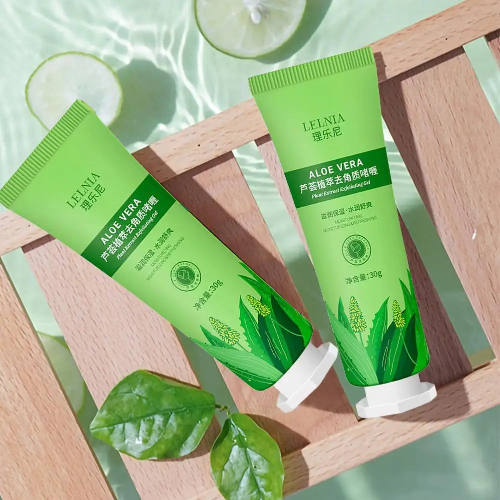 Two green aloe vera exfoliating cream tubes displayed on a wooden tray with aloe leaves.