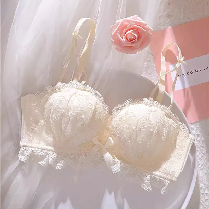 Seamless Strapless Bralette in ivory with lace detailing and adjustable shoulder straps against a soft pink background