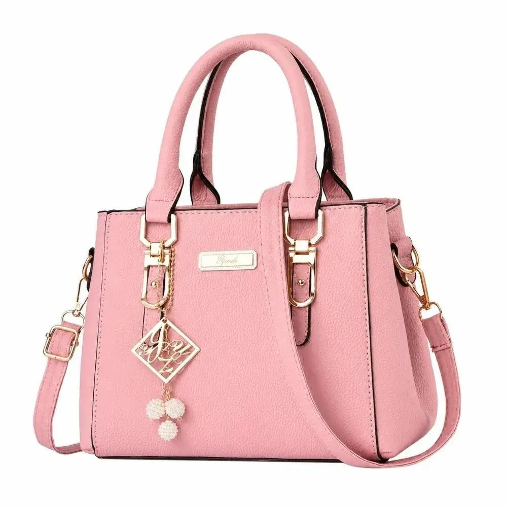 Pink structured handbag with top handles, a shoulder strap, and gold-tone hardware.