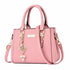 Pink structured handbag with top handles, a shoulder strap, and gold-tone hardware.