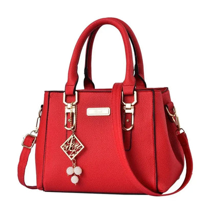 Red structured handbag with top handles and gold-tone decorative details.
