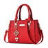 Red structured handbag with top handles and gold-tone decorative details.
